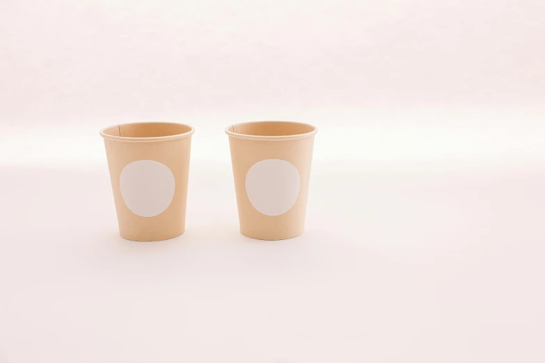 two disposable cups with spots are shown on a table