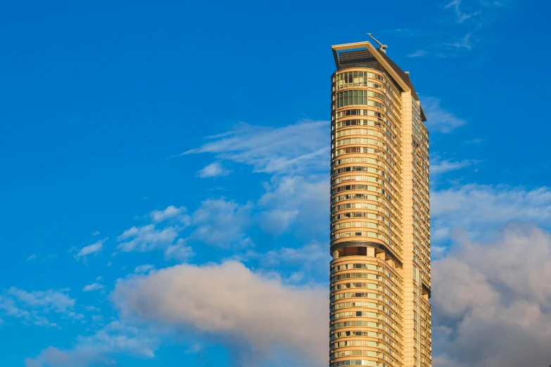 a tall tower on top of a building in the middle of a cloud filled sky