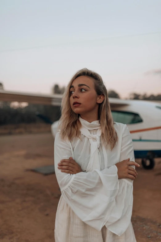 a woman standing in front of a small aircraft