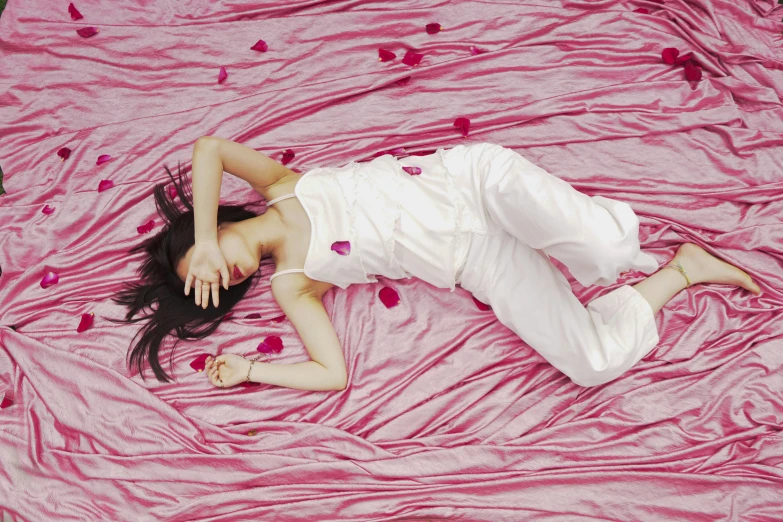 a woman lying down on top of pink cloth