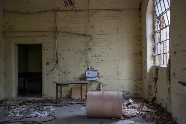 an abandoned room with peeling paint and a broken down chair and table