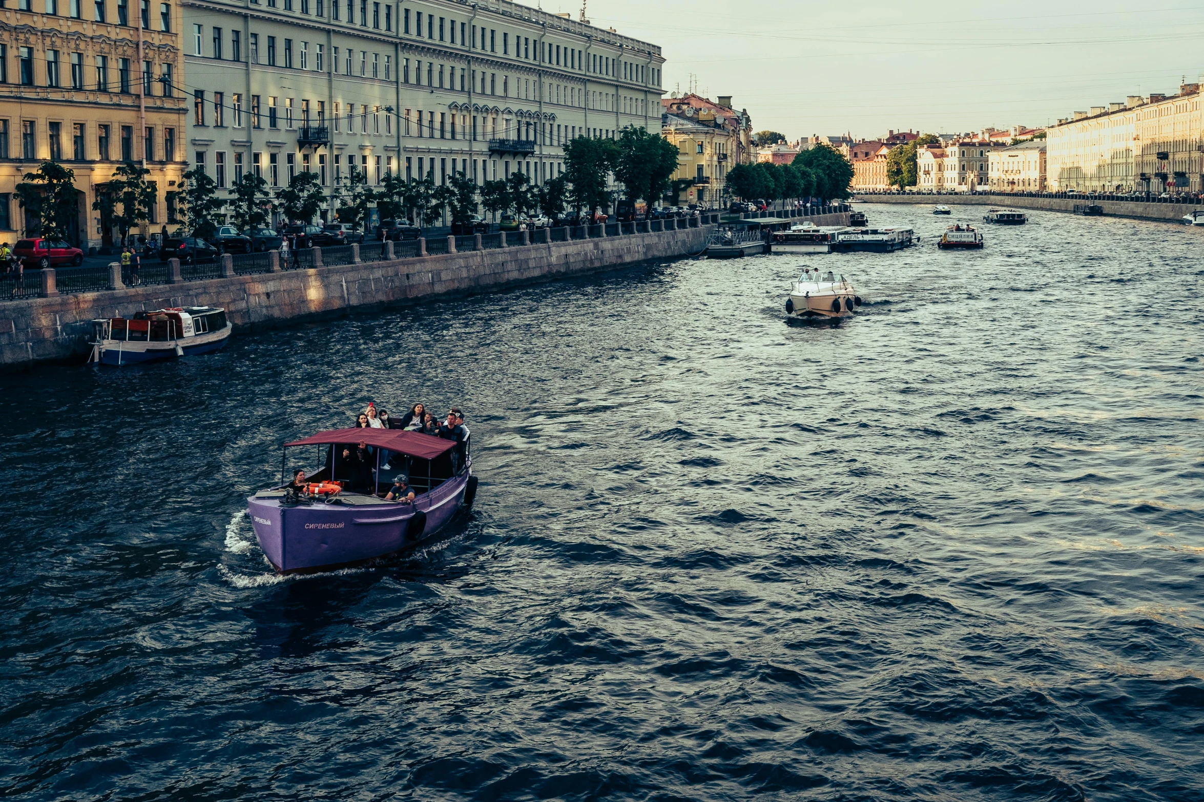 a couple of boats floating down a river next to tall buildings