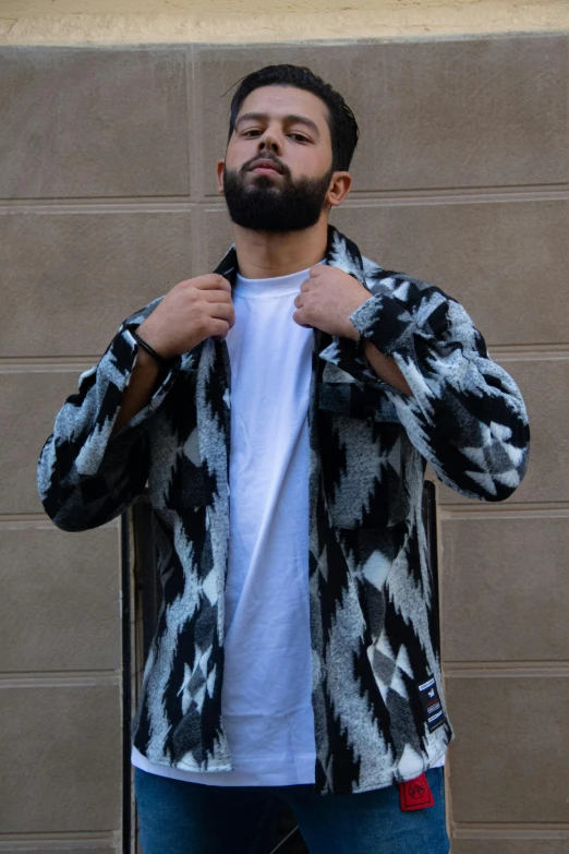 a man in a fuzzy jacket stands by a door