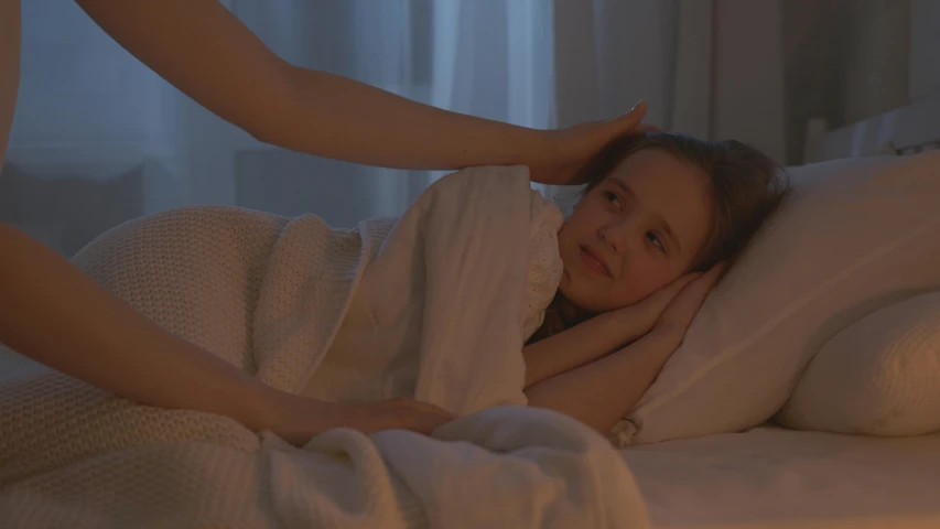 a young woman laying in a bed with her arms extended