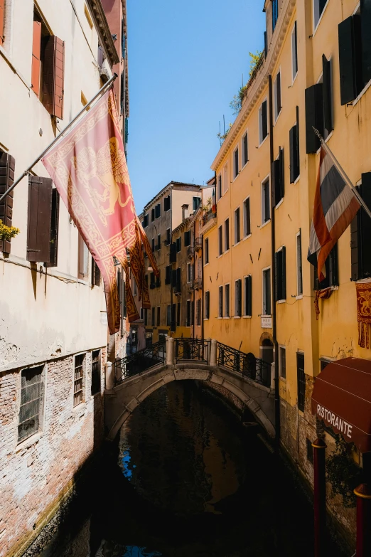 a bridge crossing over a canal between two buildings