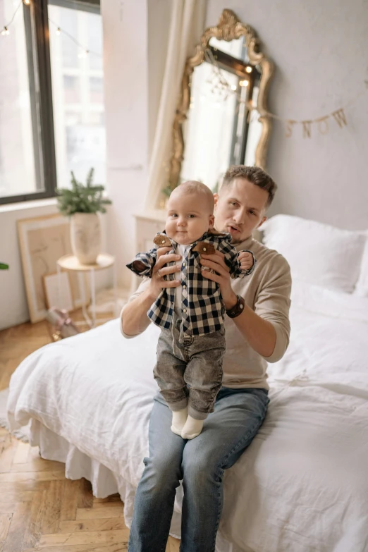 the man and the baby are sitting on the bed