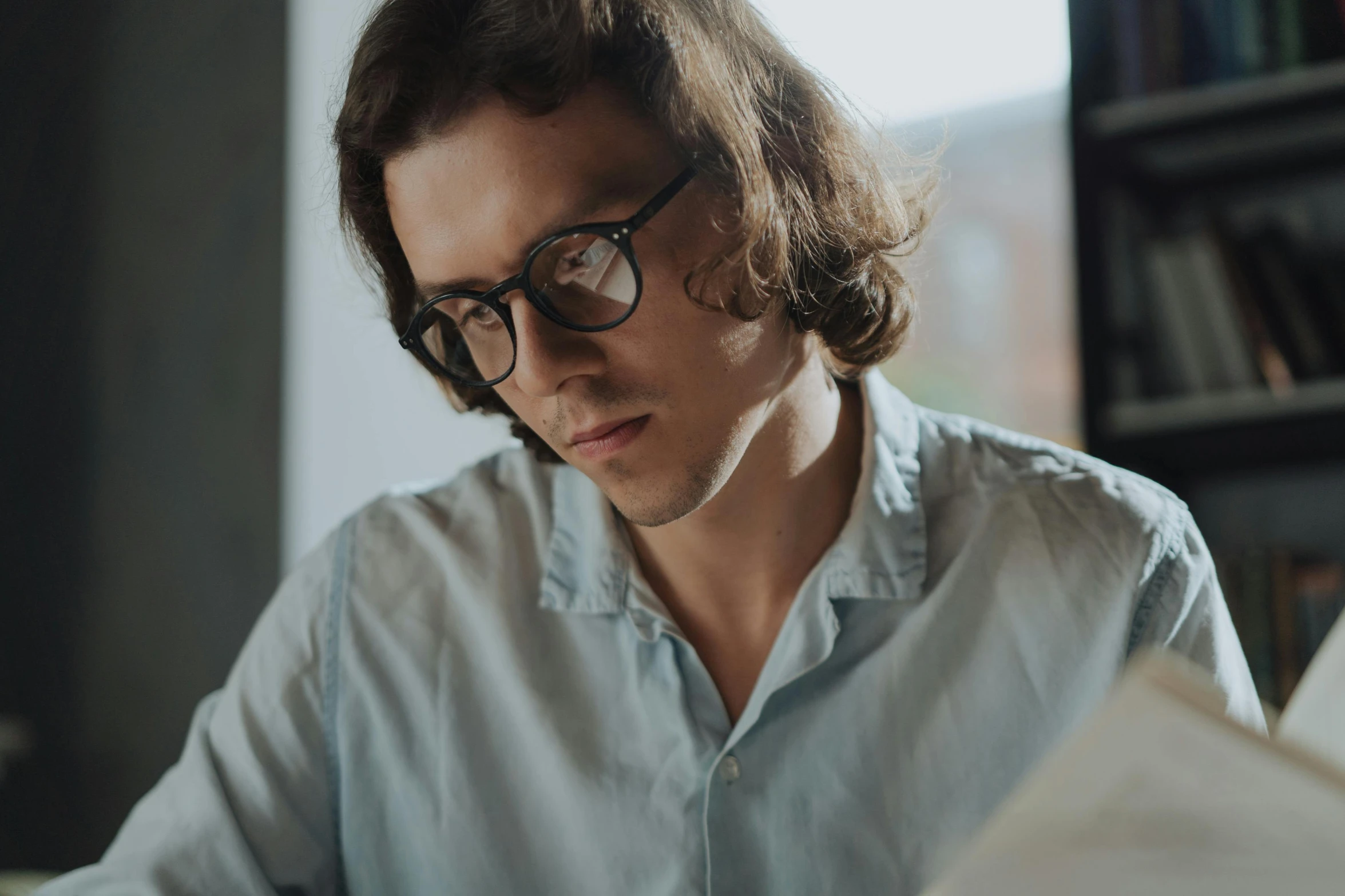 a man sitting at a desk looking through a book