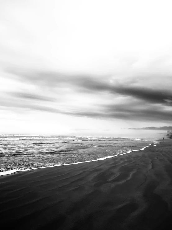 man on a surfboard walking across the beach