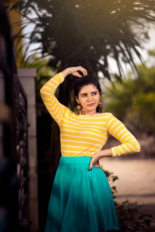 a woman in striped shirt and green skirt posing for picture