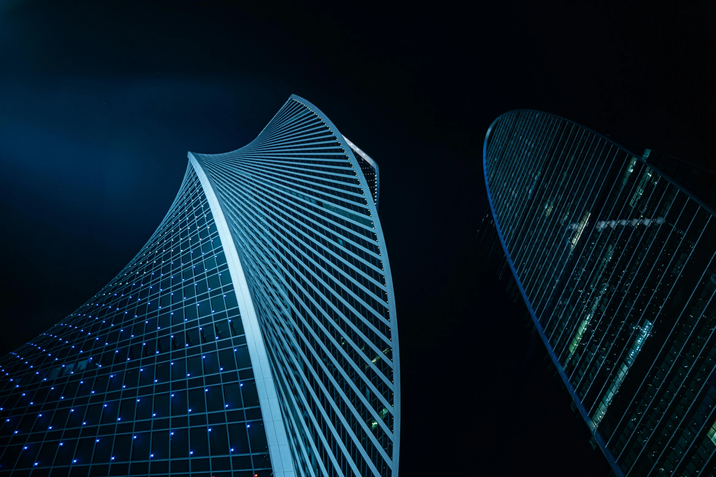 two tall buildings are lit up against a black background