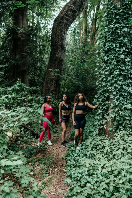 four young people are running in the forest
