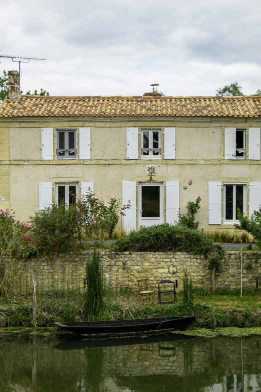 a house on the river side with a boat on the bank