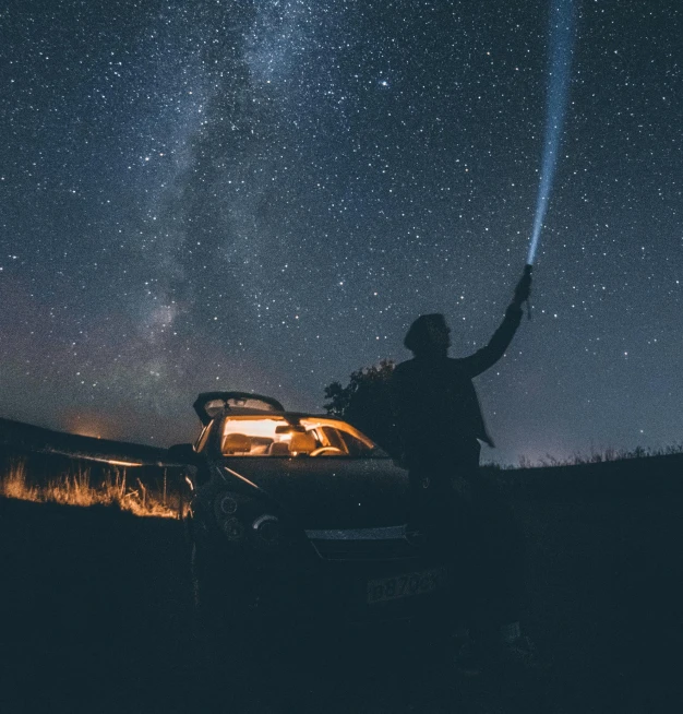 man in truck under stars in night sky