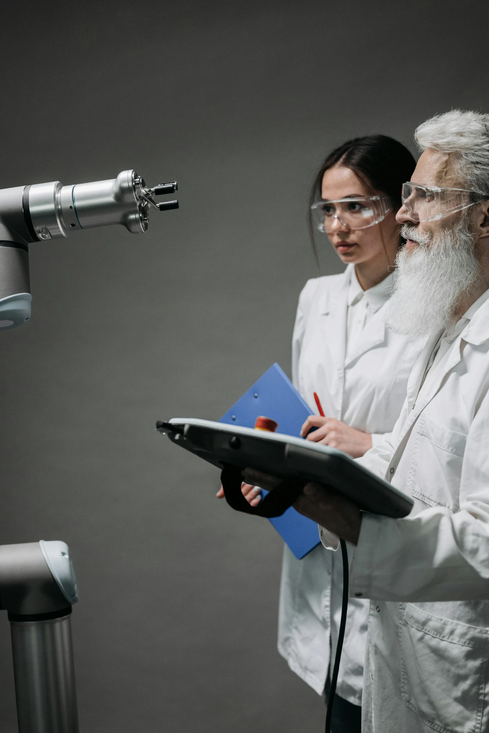 two people with a book standing next to a machine