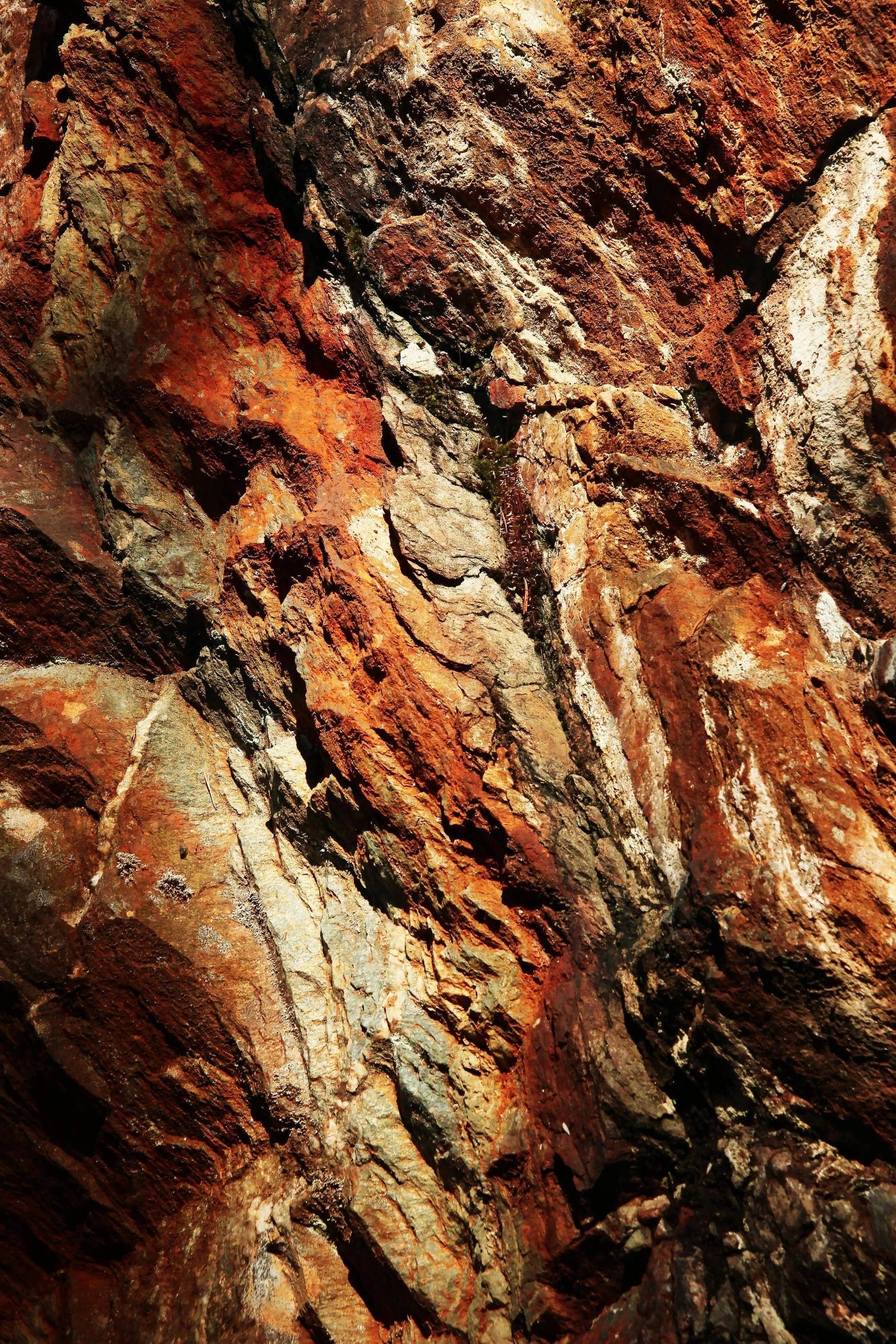 a rock face with reddish colored rocks and s