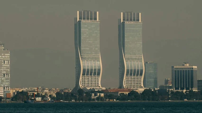 two tall buildings in a city with a body of water