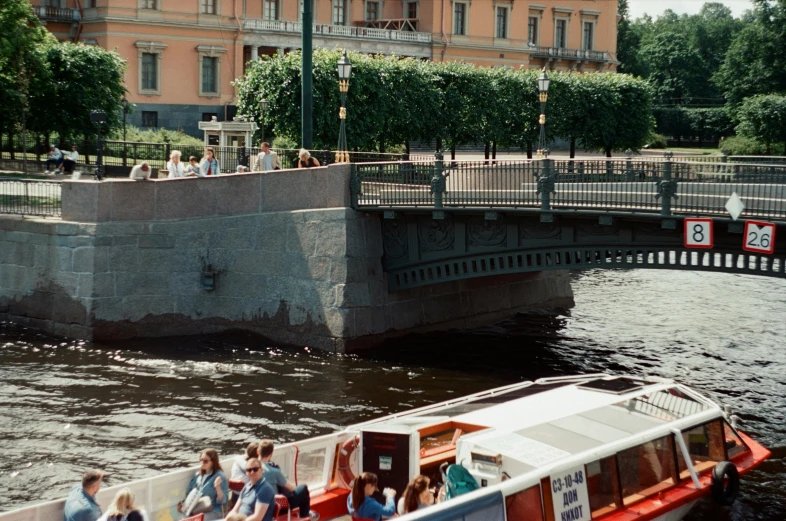 a group of people riding on top of a boat near a river