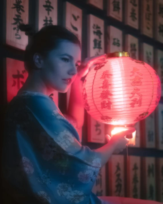 a woman holding up a lit lantern in her hand