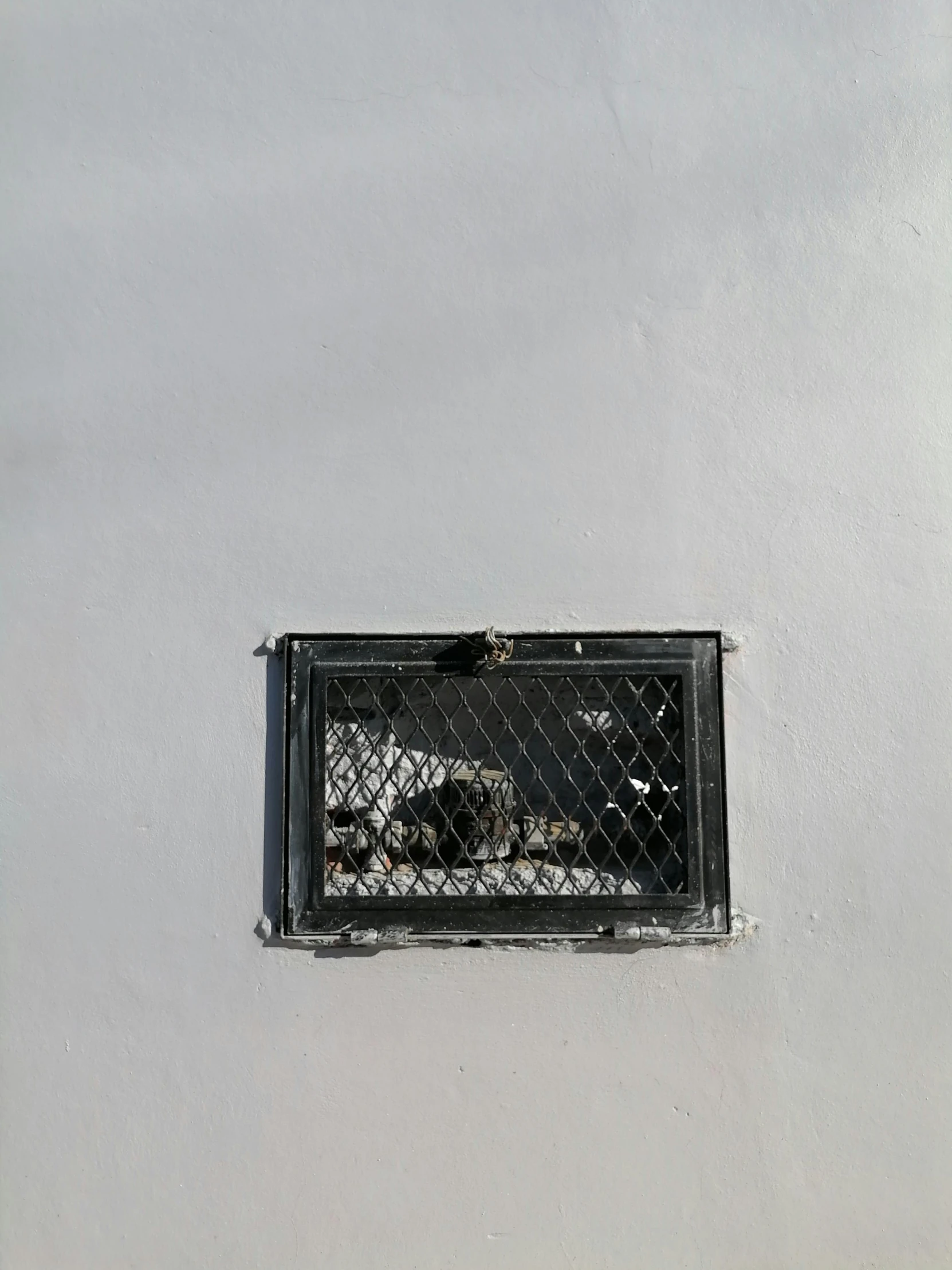 a fenced in window on the outside wall of a house