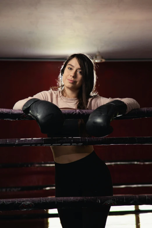 a woman with boxing gloves posing with her hand on a boxing belt