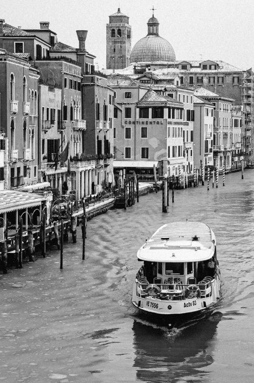 boat moving in the water with old buildings and buildings on either side