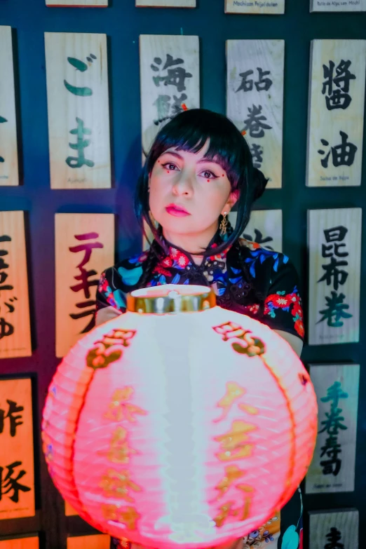 a woman standing behind a large lit vase