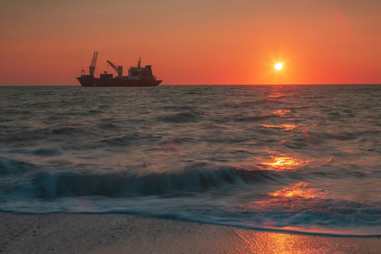 the sun rises over a boat off the shore