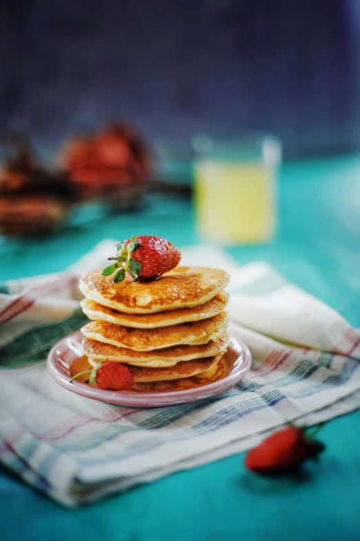 the stack of pancakes has strawberries on top