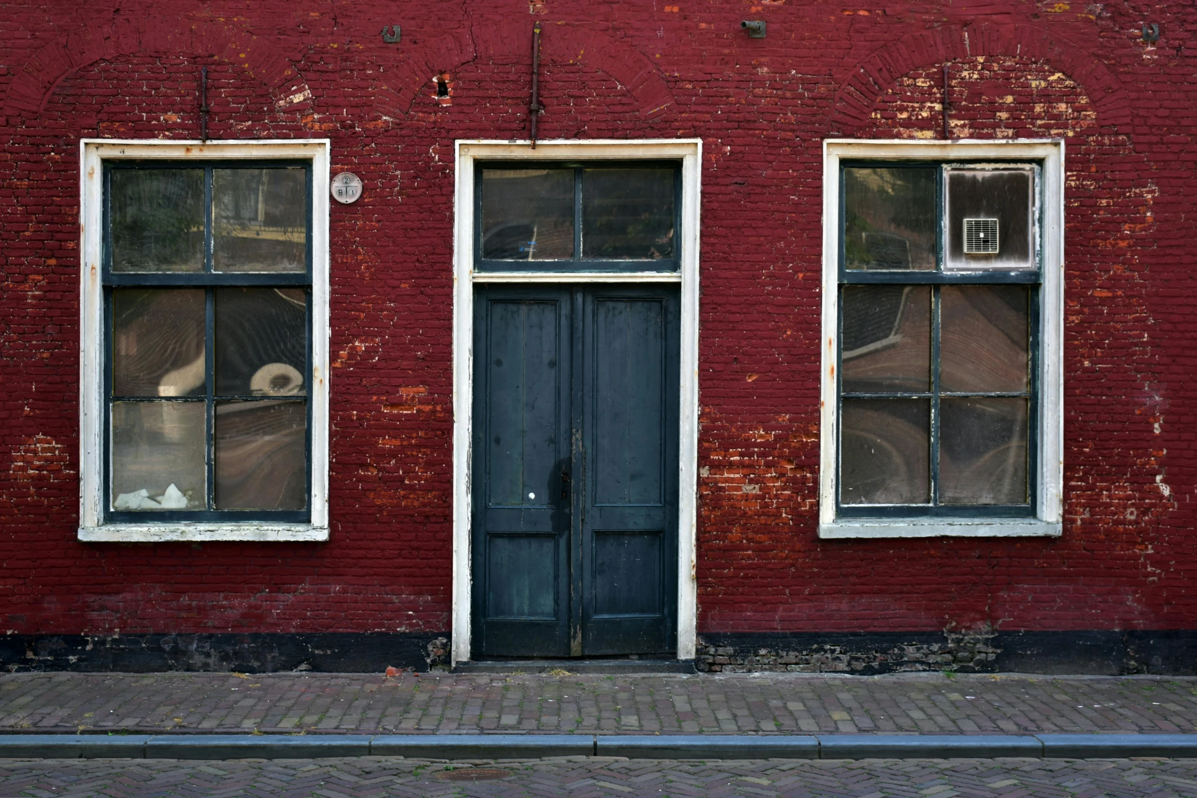 a side view of a red brick building with two windows