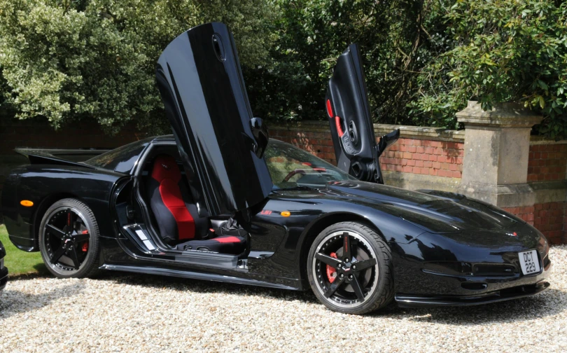 a black car that is parked in gravel