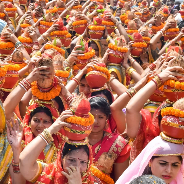 several women in colorful outfits, many holding heads full of flowers