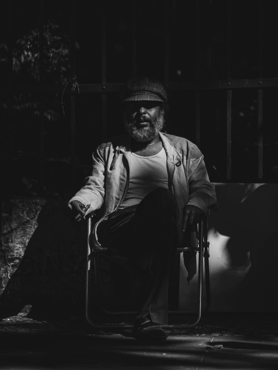 the old man sits in a chair outside his home