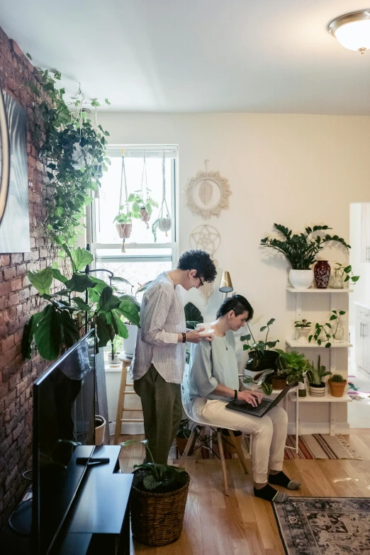 the couple stands by a plant display and watches another woman