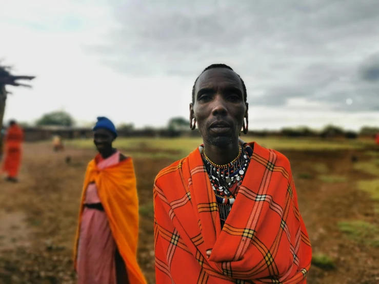 two african men stand in a large open field