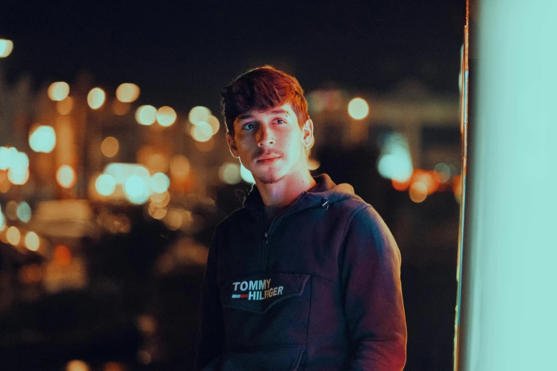 a young man posing in front of a cityscape