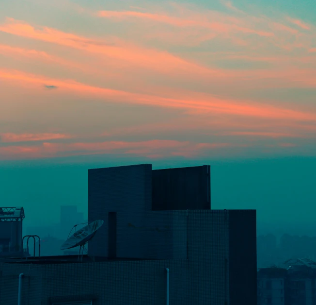 the sun is setting behind two tall buildings