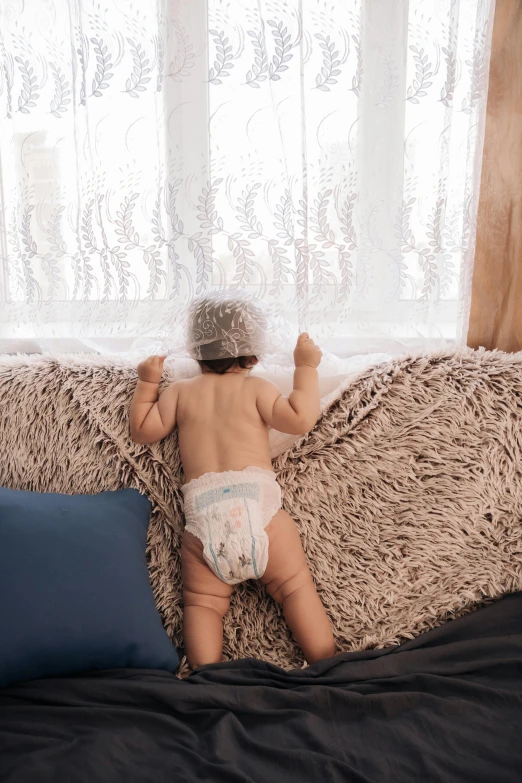 a baby boy wearing a diaper on top of a bed