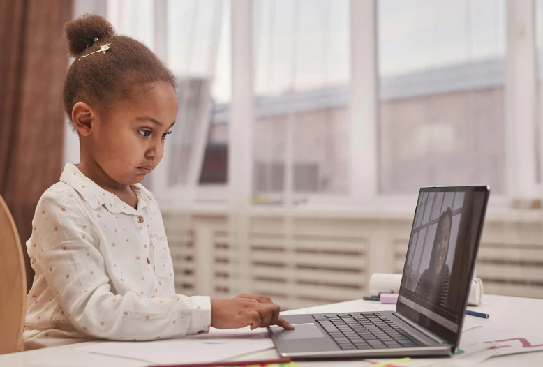 an african american child on a computer looking at a camera