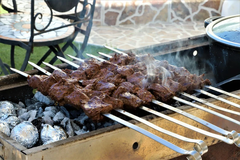 an outdoor bbq with a lot of meat on it