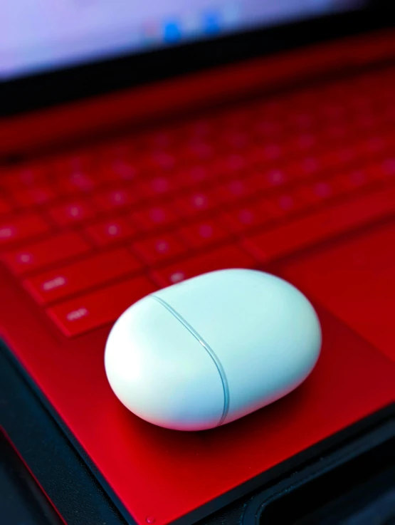 a white mouse is sitting on top of a red desk