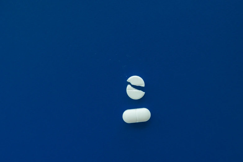 a large pill is sitting on a blue surface