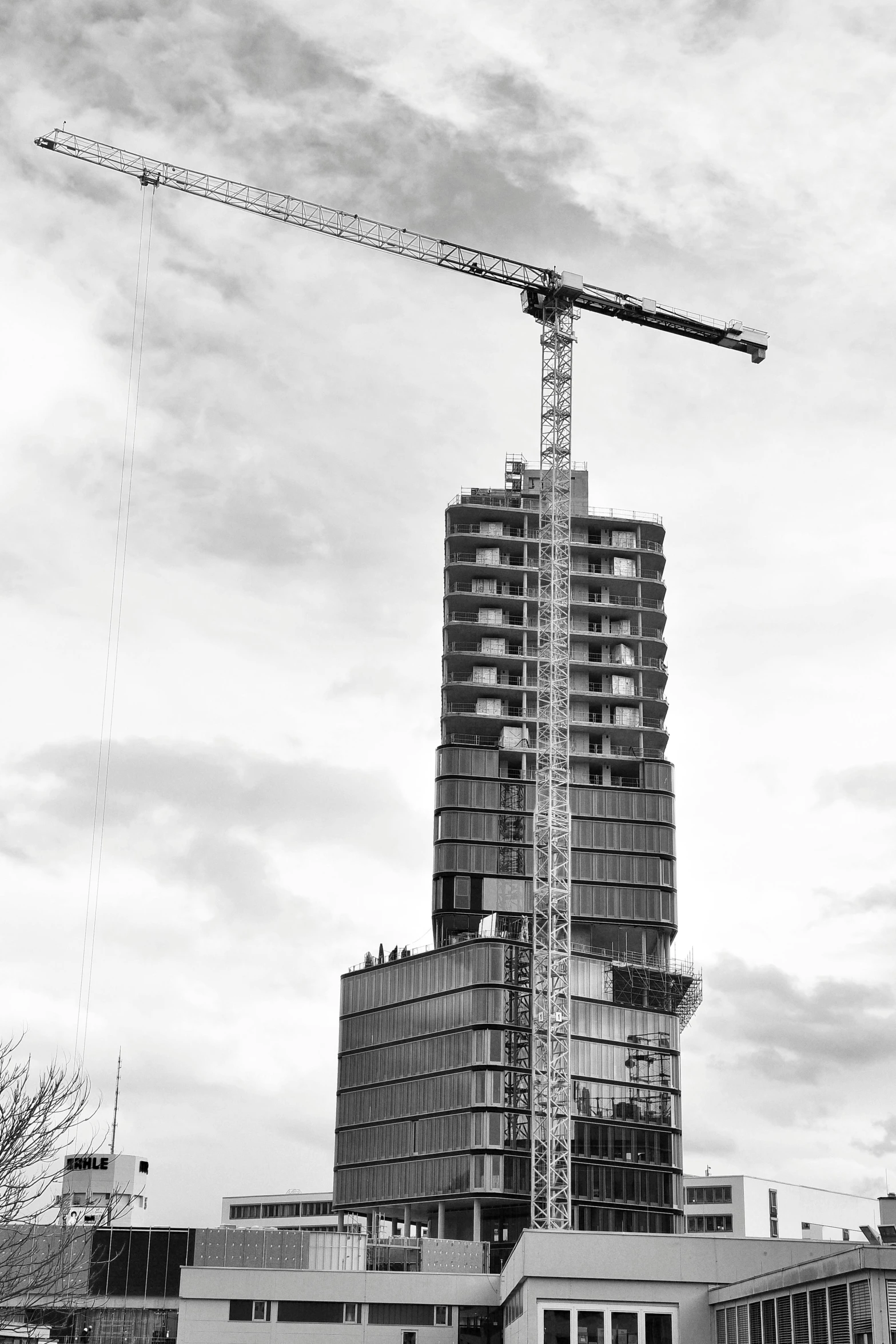 a crane is high up in the sky with a building under construction in the background