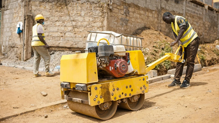 a man stands in front of a construction vehicle