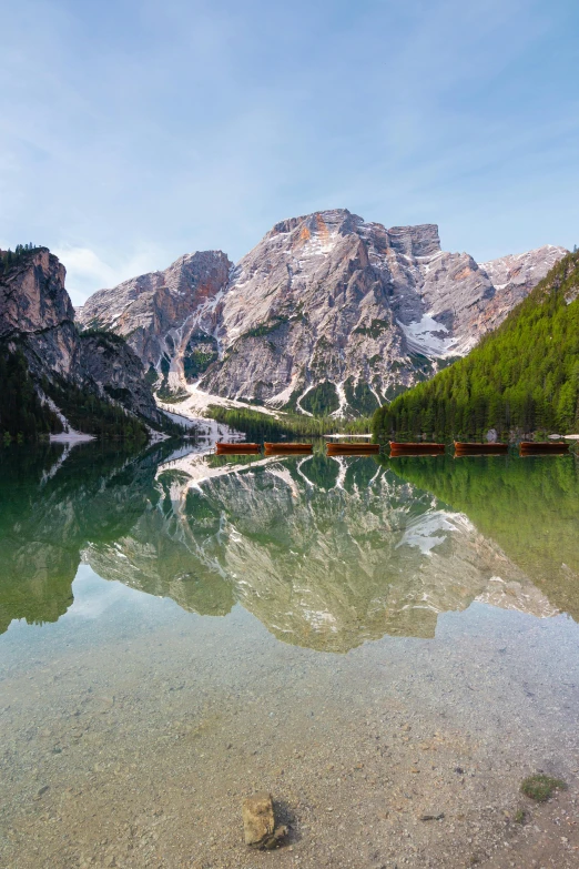 a mountain lake with several people on it and one boat near it