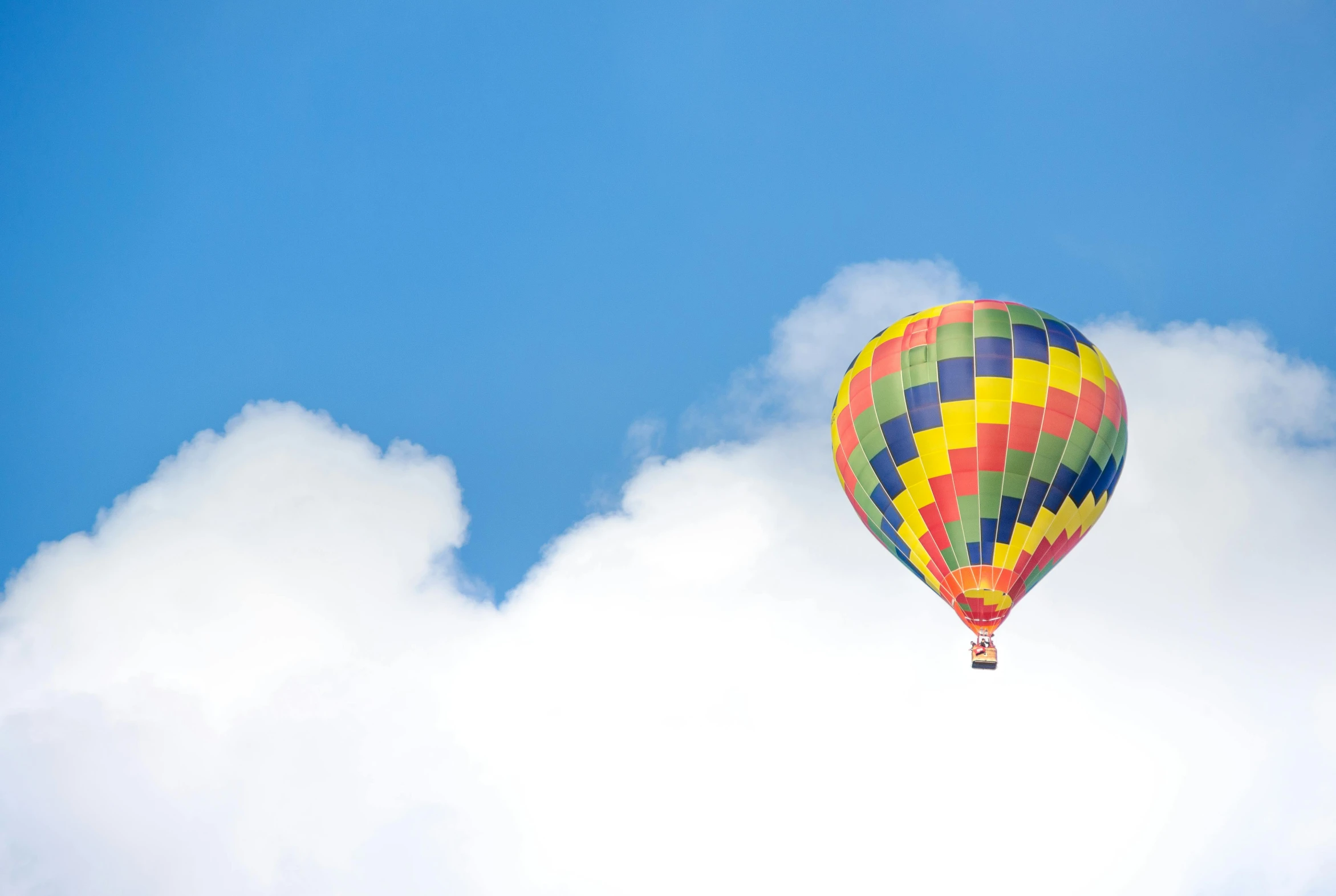 a  air balloon flying in the sky with clouds