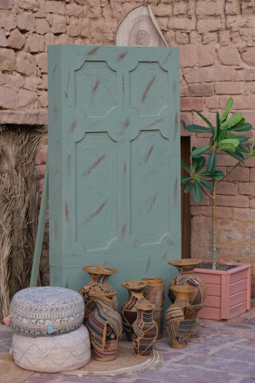 vases, and other art in front of a painted green door