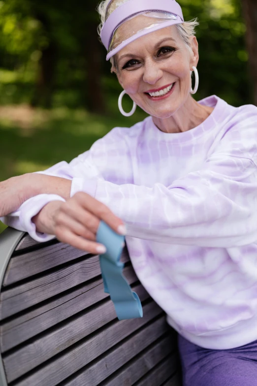 a woman sitting on top of a wooden bench