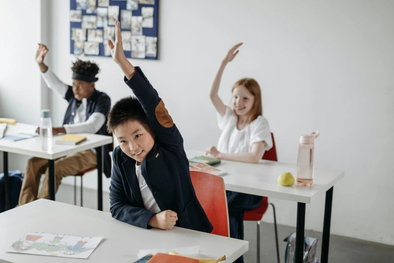 a  raising his arms in a classroom