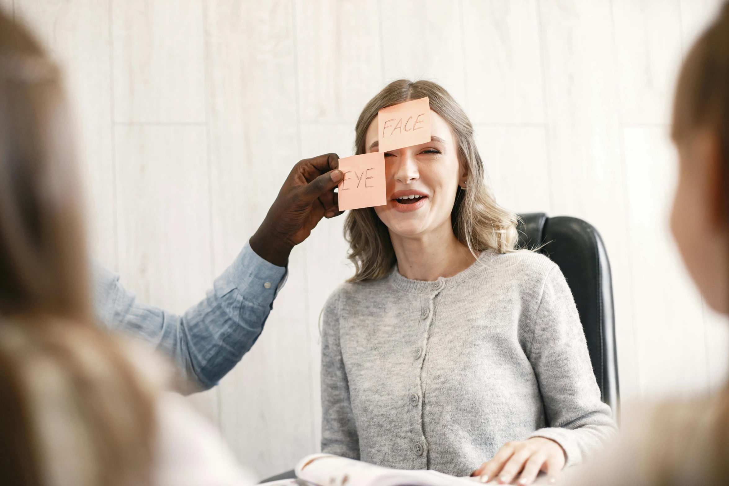 a woman with a sheet of paper near her eye