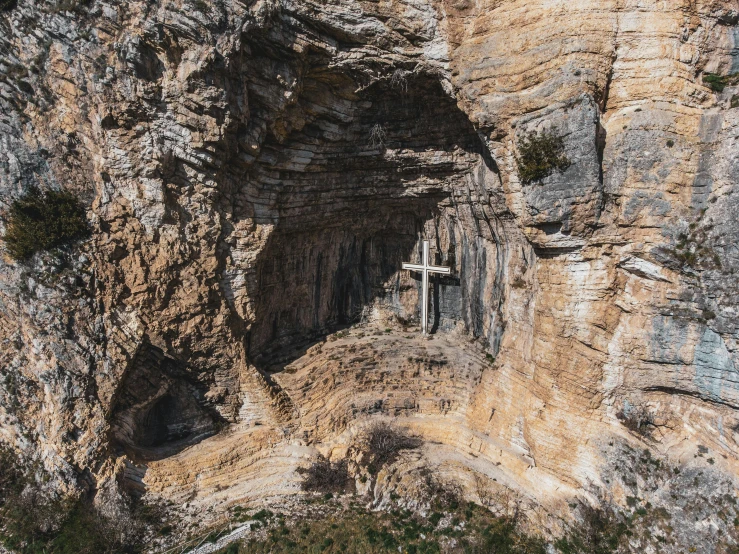 the cross is in the cave, between two large cliffs